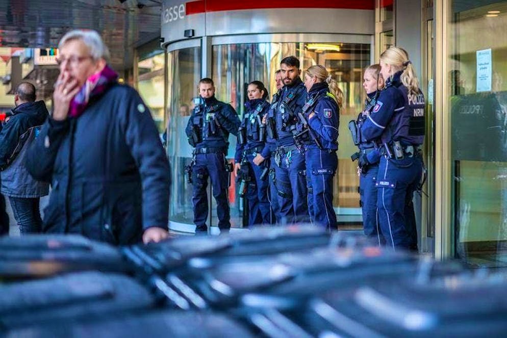 Police officers stand in front of the savings bank branch in the Buer district.
