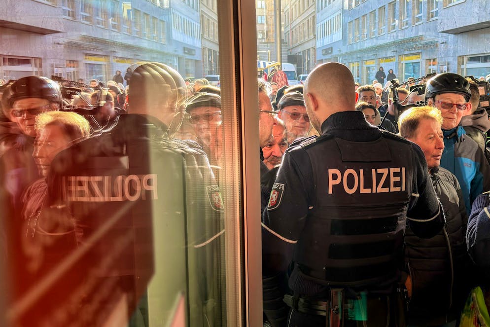 Suche nach Panzerknackern von Gelsenkirchen - Gallery. Polizisten sichern den Eingang der Sparkassenfiliale in Gelsenkirchen, vor der viele besorgte Kunde stehen und Informationen nach dem Einbruch in den Tresorraum verlangen.