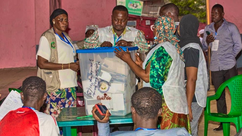 Officials prepare to count ballots at a polling station as polling stations close during the presidential election. Photo: Fode Toure/AP/dpa