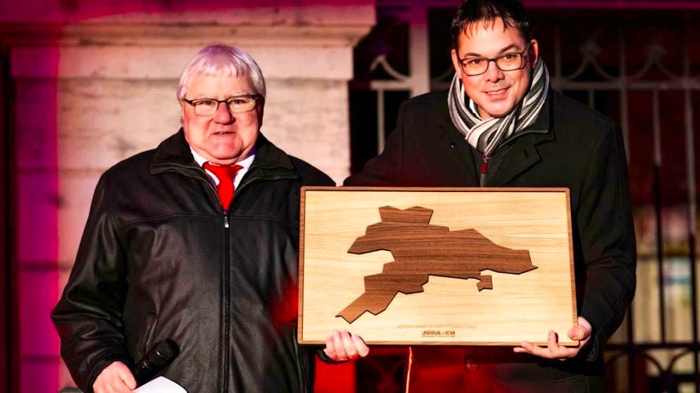 On Wednesday, Jura cantonal councillor Stéphane Theurillat (right) presents Moutier's mayor Marcel Winistoerfer (left) with a wooden map of the canton of Jura, which already includes the town of Moutier as part of the canton of Jura.