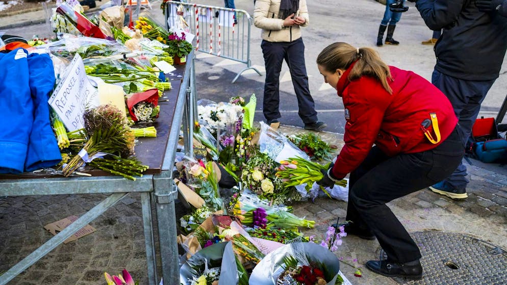 A woman lays flowers in memory of the victims of the fire disaster in Crans-Montana.