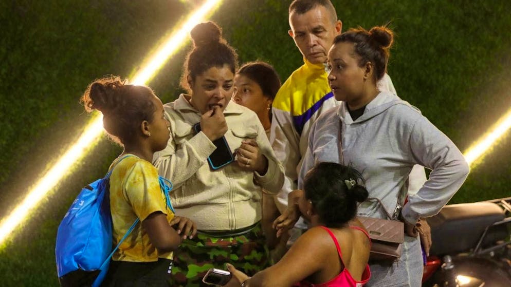 Residents from a building that was evacuated stand near the Miraflores presidential palace after explosions and low-flying planes were heard in Caracas, Venezuela, Saturday, Jan. 3, 2026. Photo: Cristian Hernandez/AP/dpa