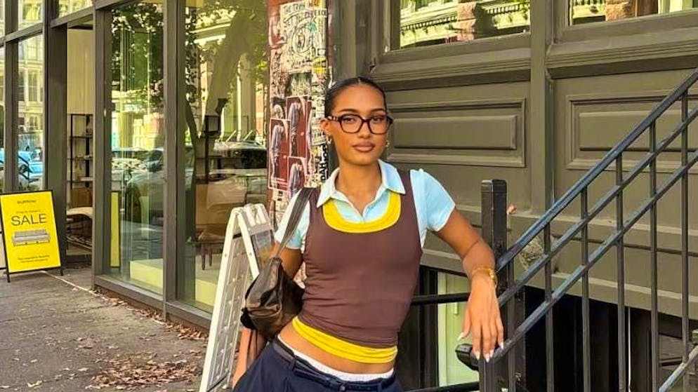 Layering clothes is becoming a fashion trend. The woman in the picture is wearing three shirts on top of each other - super fashionable.