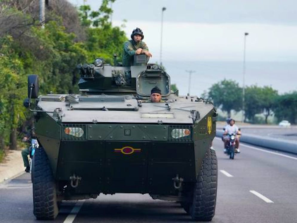 Ein Soldat steht auf einem gepanzerten Fahrzeug auf der Autobahn, die vom internationalen Flughafen nach Caracas führt.