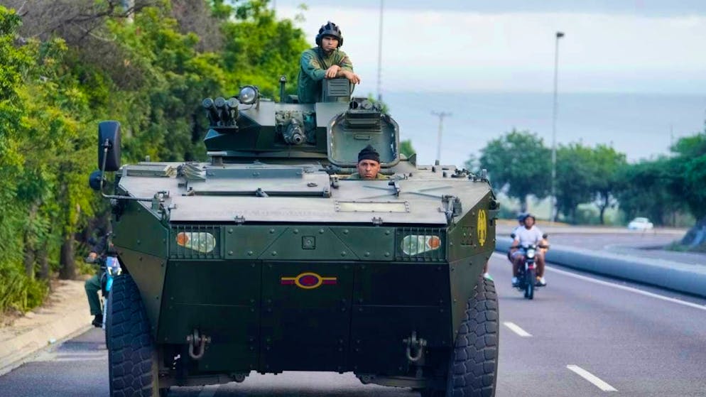 A soldier stands on an armored vehicle on the highway leading from the international airport to Caracas. Photo: Matias Delacroix/AP/dpa