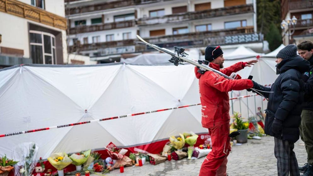 Un monitore di sci rilascia un'intervista ai media vicino al bar "Le Constellation", sigillato dopo il devastante incendio di Capodanno.