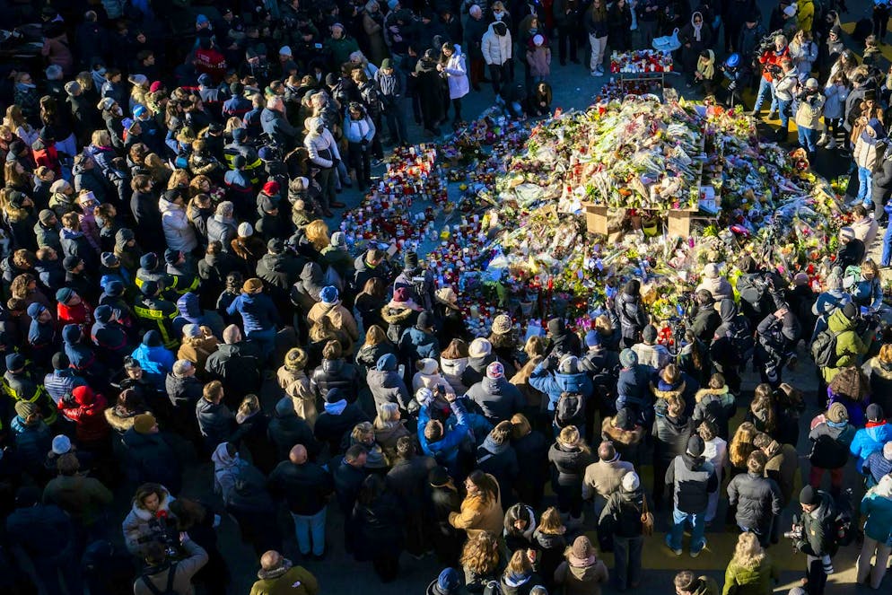 I fedeli si riuniscono intorno a fiori e candele per commemorare le vittime dell'incendio del bar e lounge «Le Constellation», a Crans-Montana, in Svizzera, domenica 4 gennaio 2026.
