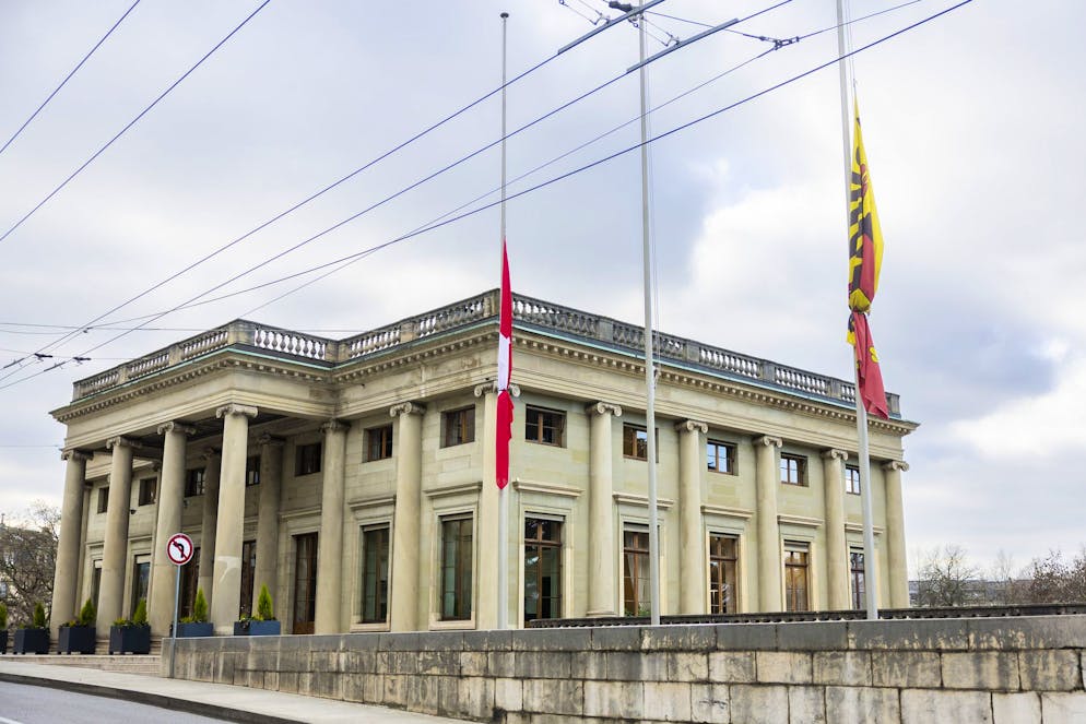 Una bandiera svizzera, a sinistra, e una bandiera di Ginevra sventolano a mezz'asta davanti al Palazzo Eynard, sede del Consiglio amministrativo di Ginevra.