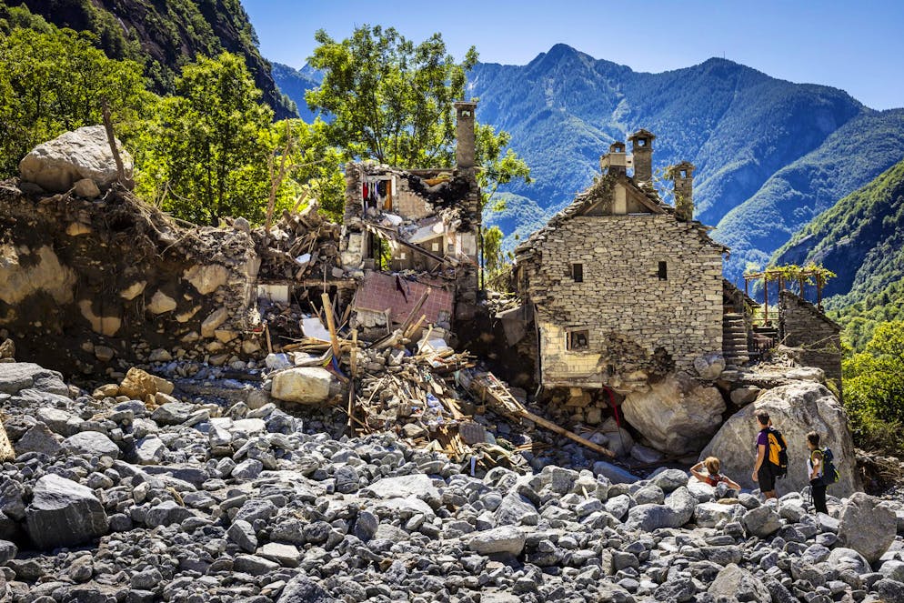 Giovedì 4 luglio 2024, alcune persone ispezionano le case distrutte da una massiccia frana a Fontana, nella Val Bavona, nella Valle Maggia, nel sud della Svizzera. Le violente tempeste e le piogge torrenziali dello scorso fine settimana hanno causato la morte di cinque persone nella Val Maggia e nelle valli laterali del Ticino.