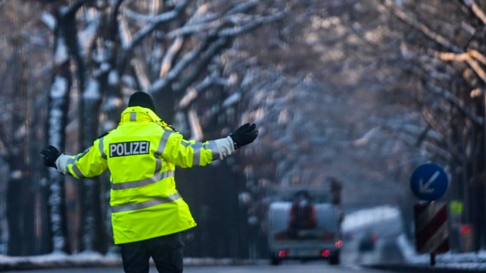 Ein Polizist regelt den Verkehr an einer Kreuzung, an der die Ampel ausgefallen ist. Zehntausende Menschen im Südwesten der Hauptstadt haben keinen Strom. Foto: Britta Pedersen/dpa