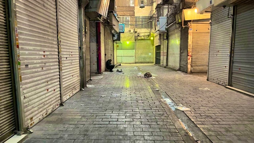A man sits next to closed stores in Tehran's centuries-old main bazaar (archive photo). Photo: Vahid Salemi/AP/dpa