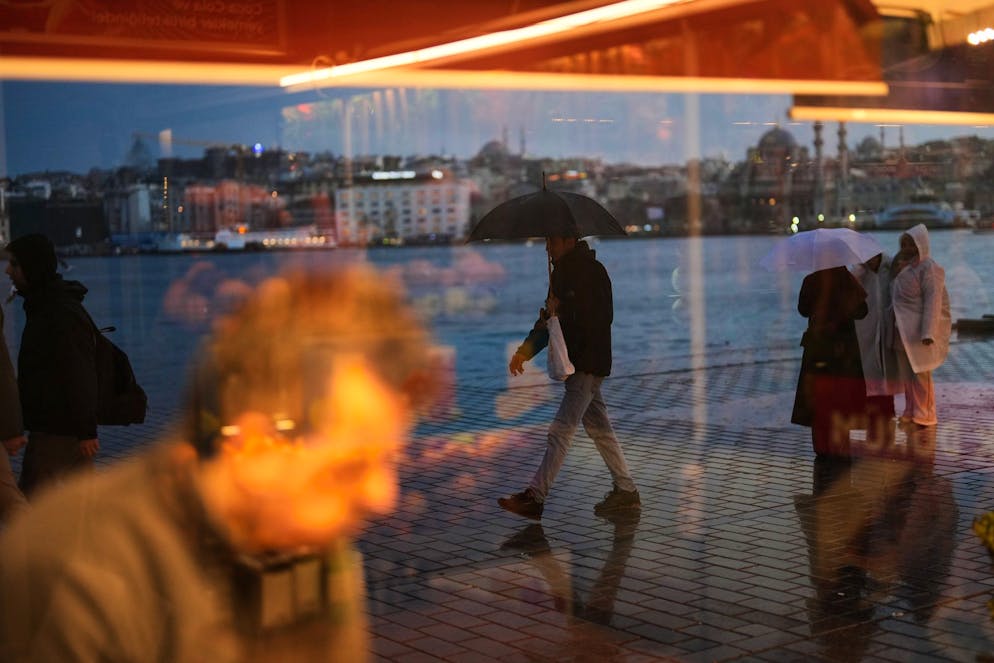 Un homme muni d'un parapluie passe devant l'objectif par une journée pluvieuse d'hiver à Istanbul, en Turquie, le jeudi 8 janvier 2026. (AP Photo/Francisco Seco)