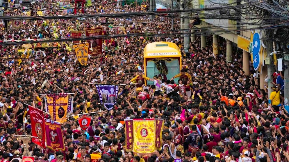 Catholic believers gather around the carriage with the image of the Black Nazarene during the annual procession. Photo: Aaron Favila/AP/dpa