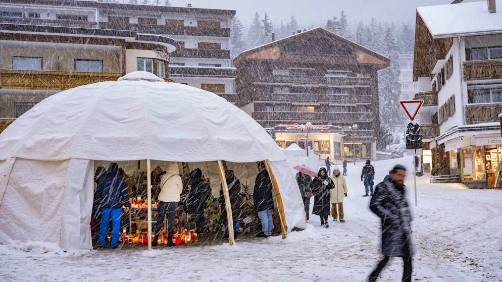 Vor der Inferno-Bar in Crans-Montana finden die Trauernden, die Blumen und Kerzen für die Opfer des Brandes bringen, am Donnerstag in einem Zelt Zuflucht. 
