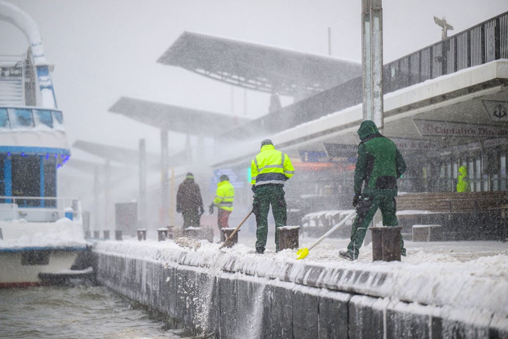 Intempéries. Des ouvriers déblayent la neige et la poussent dans l'Elbe lors d'une forte chute de neige à Landungsbruecken, à Hambourg, en Allemagne, le 9 janvier 2026. La tempête Elli a frappé le nord de l'Allemagne, accompagnée de vents violents et de neige. (Photo de DANIEL REINHARDT / AFP)
