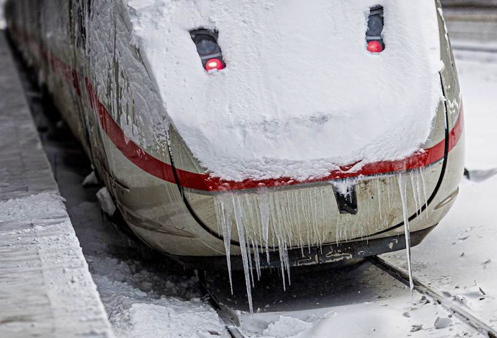Ein ICE steht mit langen Eiszapfen im verschneiten Hauptbahnhof Hannover.
