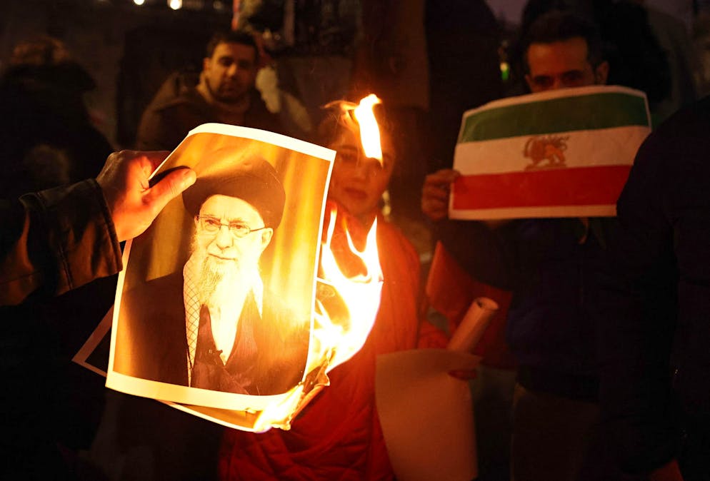 I manifestanti danno fuoco a un ritratto del leader supremo iraniano Ali Khamenei mentre partecipano a una manifestazione a sostegno dell'attuale movimento di protesta in Iran.