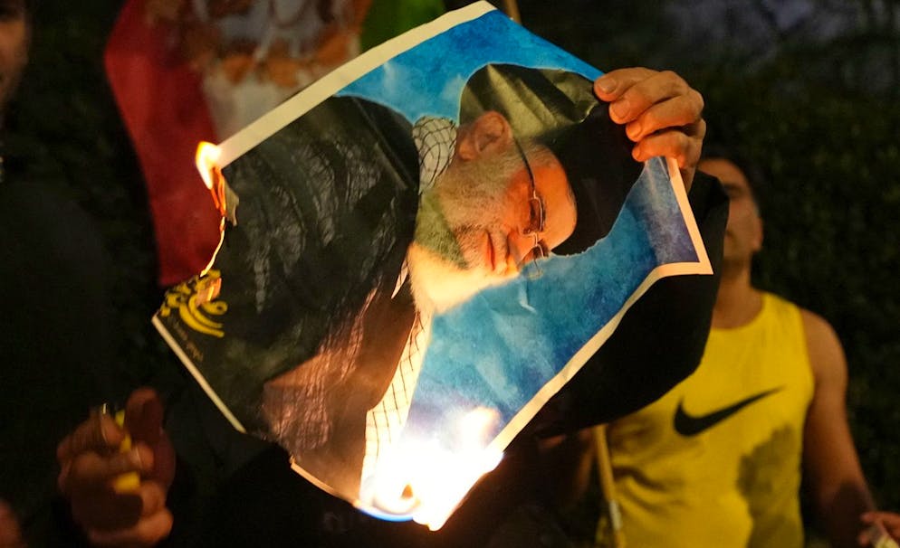 Una foto dell'ayatollah Ali Khamenei viene bruciata dai manifestanti. 