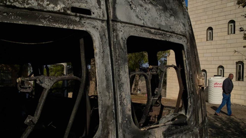 ARCHIV - Moussab Mshala geht an einem Fahrzeug vorbei, das bei einem Angriff israelischer Siedler vor seinem Haus im Westjordanlanddorf al-Jab'a in der Nähe von Bethlehem verbrannt ist. Foto: Leo Correa/AP/dpa