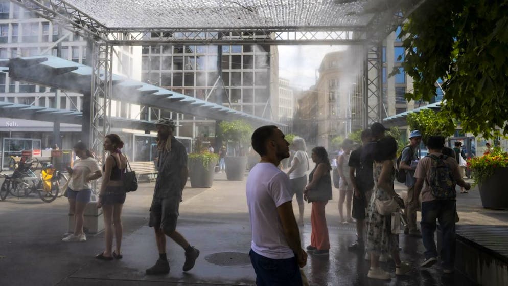 Image d'illustration: des personnes profitent d'un brumisateur géant installé par la ville de Geneve afin de se rafraichir durant la canicule, à Genève, en juillet dernier.