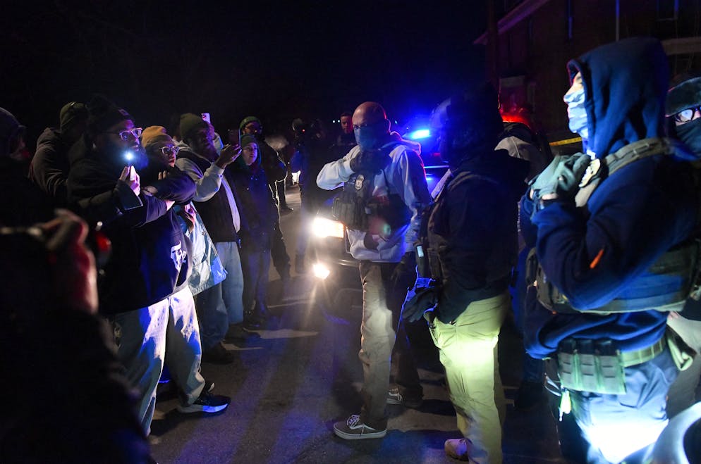 Des agents masqués de l’ICE et des manifestants se font face alors que des protestations ont éclaté après que des agents de l’Immigration and Customs Enforcement (ICE) ont tiré sur un homme vénézuélien à Minneapolis, dans le Minnesota, le 14 janvier 2026.