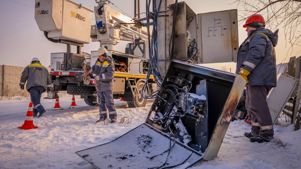 Elektriker reparieren am Mittwoch in Kiew bei schweren russischen Luftangriffen beschädigte Strommasten. Die Versorgungsnetze der ukrainischen Hauptstadt waren am vergangenen Freitag (9.1.) ausser Gefecht gesetzt worden. 