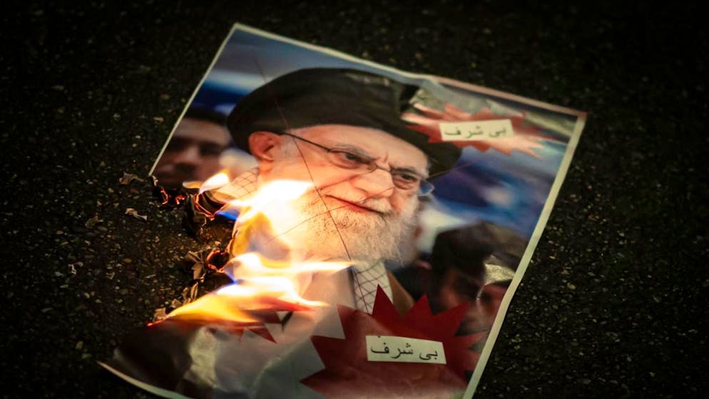 Un'immagine dell'ayatollah Khamenei bruciata da manifestanti anti-regime.
