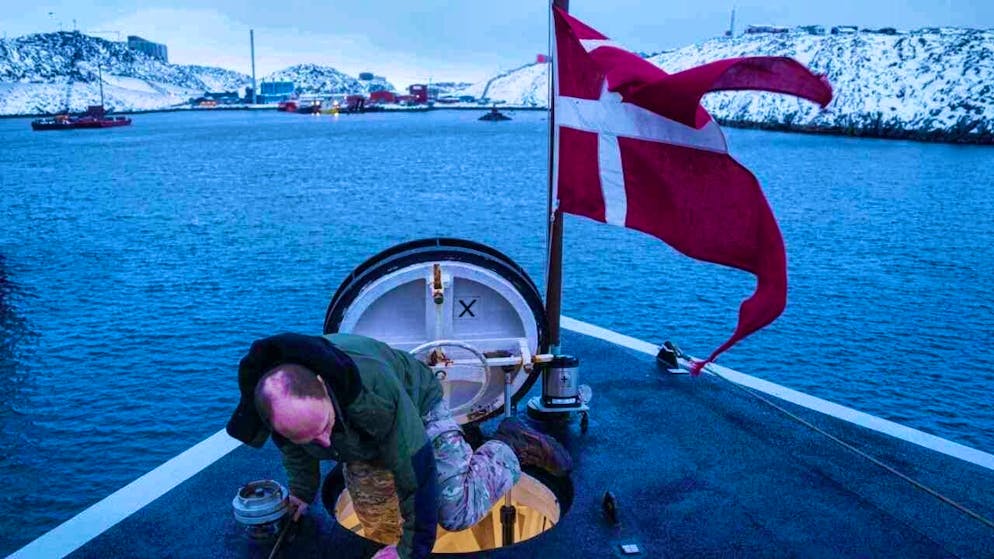 ARCHIVE - A Danish soldier climbs out of a hatch on the bow of the Royal Danish Navy military ship HDMS Knud Rasmussen, anchored off Nuuk. Photo: Evgeniy Maloletka/AP/dpa