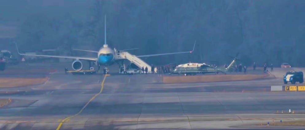 Trump's entourage transfers from Air Force One to the Marine One helicopter.