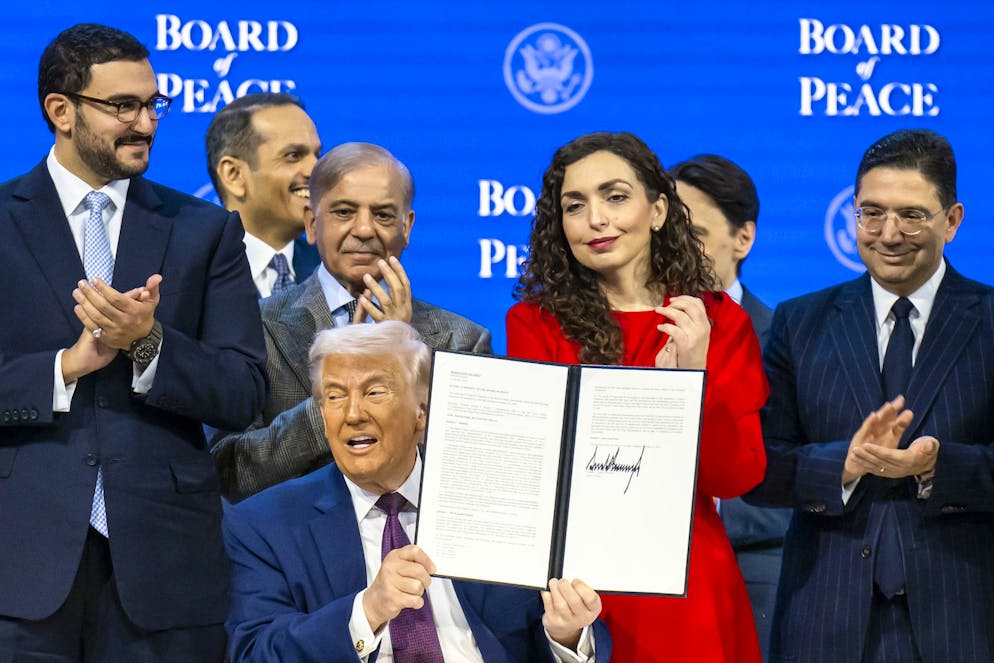 Donald Trump mostra in trionfo il documento firmato che sigla la nascita del Board of Peace.