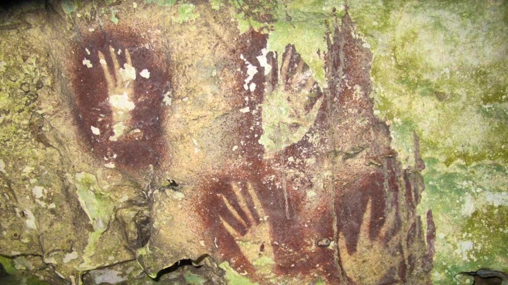 This undated image by Maxime Aubert shows handprints with sharpened fingertips in the Maros region of Sulawesi in Indonesia.