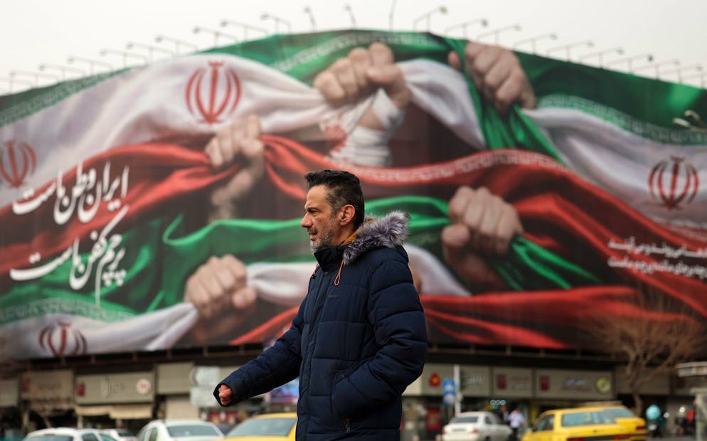 epa12661030 Un Iranien marche à côté d'un panneau d'affichage sur lequel on peut lire en persan « L'Iran est notre patrie » dans une rue de Téhéran, en Iran, le 19 janvier 2026. L'Iran connaît une coupure nationale d'Internet qui a débuté le 8 janvier 2026, dans un contexte de vague croissante de manifestations antigouvernementales. EPA/ABEDIN TAHERKENAREH