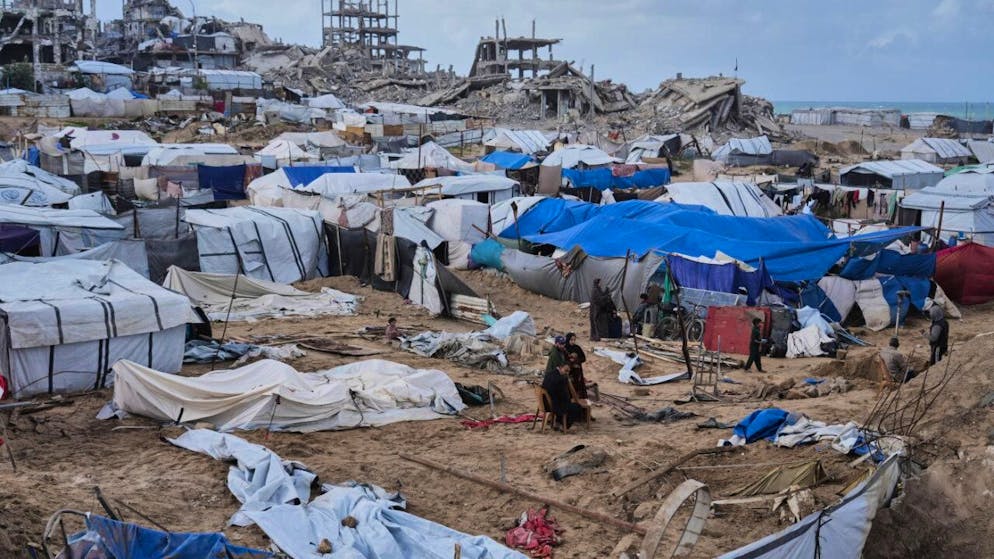 ARCHIV - Palästinenser inspizieren beschädigte Zelte in einem Vertriebenenlager im Gazastreifen. Foto: Jehad Alshrafi/AP/dpa/Archivbild