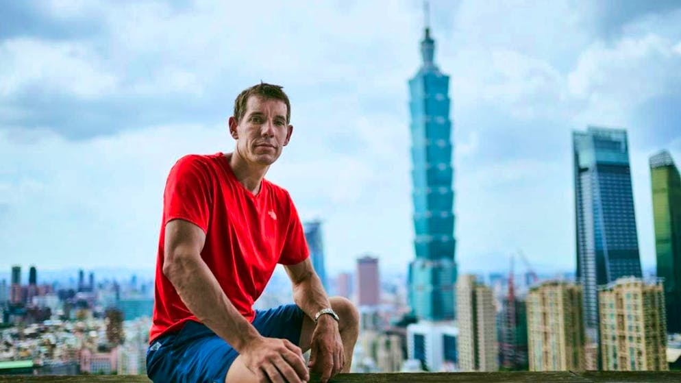 HANDOUT - Alex Honnold sits on a railing in front of skyscrapers in Taipei. On Saturday night (24.01.2026) at 02:00 (CET), free climber Alex Honnold will scale one of the world's tallest skyscrapers, Taipei 101. The action will be streamed live on Netflix. Photo: Corey Rich/Netflix/dpa - ATTENTION: For editorial use only in connection with the current coverage of the Netflix live stream and only with full attribution of the above credit