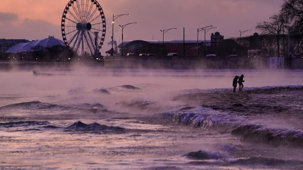 dpatopbilder - Menschen spazieren in Chicago über einen mit Eis bedeckten Strand am Ufer des Michigansees. Foto: Kiichiro Sato/AP/dpa