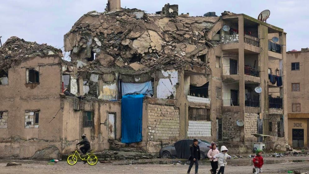 Children walk past a damaged residential building in Raqqa in northern Syria. Photo: Ghaith Alsayed/AP/dpa