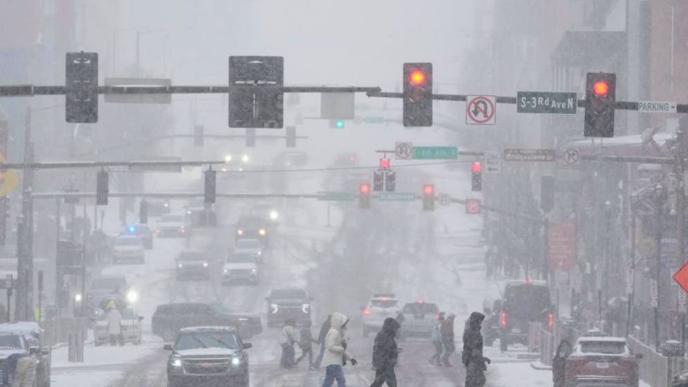 dpatopbilder - Fußgänger überqueren die Straße am Broadway während eines Wintersturms in Nashville. Foto: George Walker IV/AP/dpa