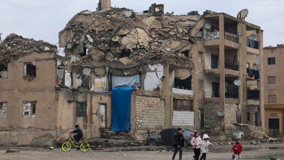 Kinder laufen an einem beschädigten Wohnhaus in Raqqa in Nordsyrien vorbei. Foto: Ghaith Alsayed/AP/dpa