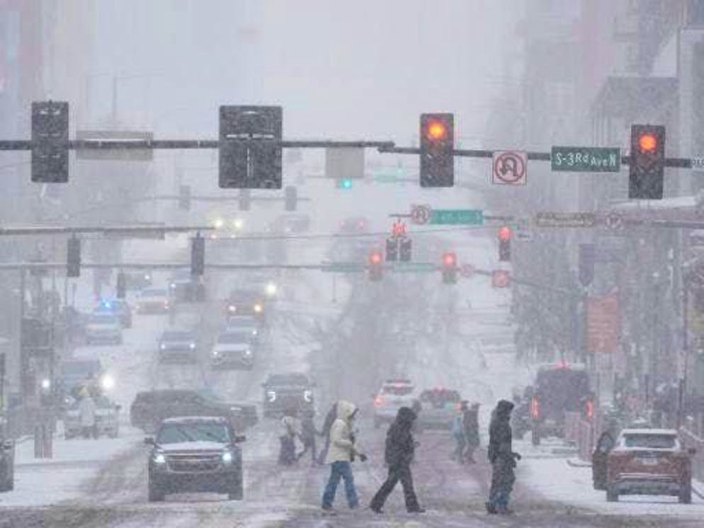 Winter storm moves across the USA. Pedestrians cross the street on Broadway during a winter storm in Nashville.