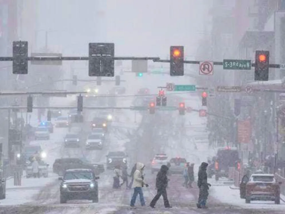 Una tempesta invernale attraversa gli Stati Uniti. Pedoni attraversano la strada a Broadway durante una tempesta invernale a Nashville.