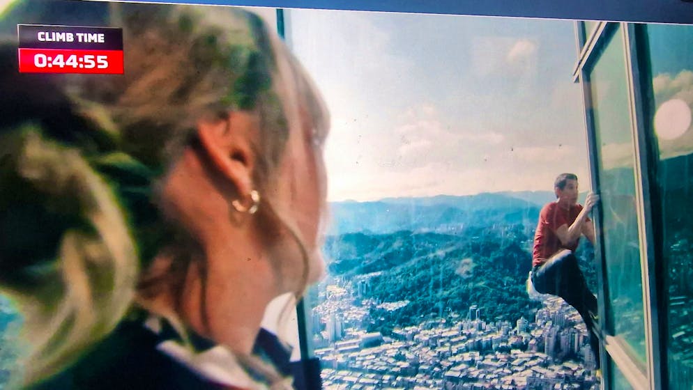 Surreale: Honnold non assicurato sul Taipei 101, mentre viene ammirato e incitato dalle persone negli uffici.