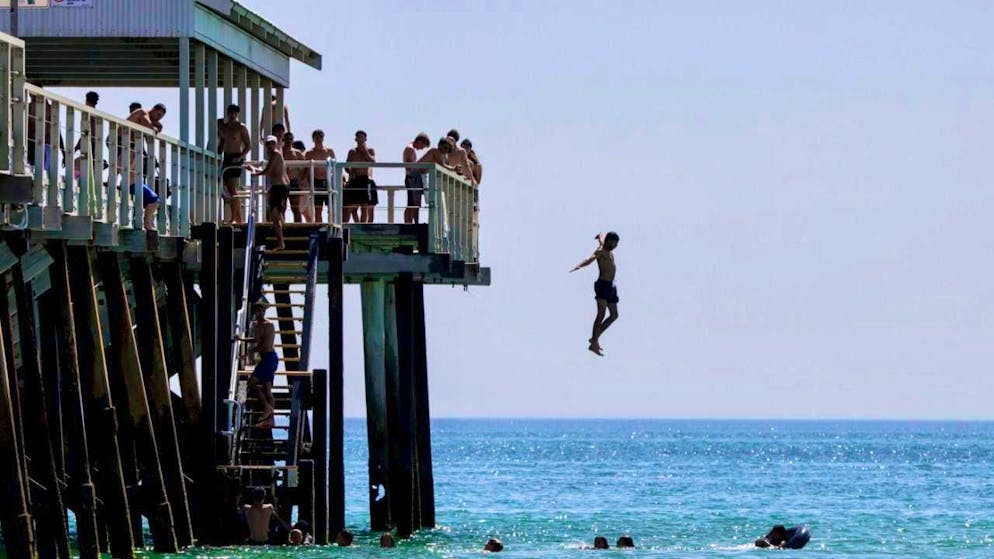 dpatopbilder - Jetty jumpers escape the heat in Adelaide. Temperatures are expected to reach 40 degrees in some cities on Australia Day as the southern states swelter in a record-breaking heatwave. Photo: Matt Turner/AAP/dpa