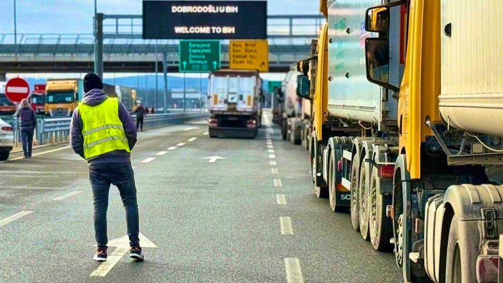 A man stands next to a line of trucks and buses on the Bosnian side of the border with Croatia in Svilaj, Bosnia. Photo: Eldar Emric/AP/dpa