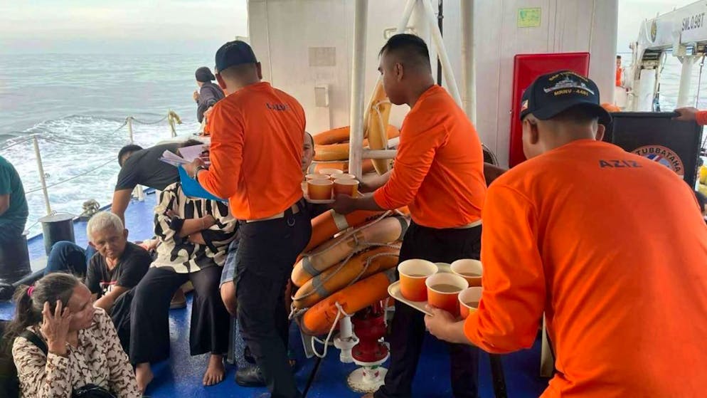 HANDOUT - Dieses von der philippinischen Küstenwache veröffentlichte Foto zeigt Mitarbeiter der philippinischen Küstenwache, die sich um Menschen kümmern, die sich an Bord der M/V Trisha Kerstin 3 in den Gewässern der Insel Baluk-baluk, Basilan, Philippinen, befanden. Foto: Uncredited/Philippine Coast Guard/dpa - ACHTUNG: Nur zur redaktionellen Verwendung im Zusammenhang mit der aktuellen Berichterstattung und nur mit vollständiger Nennung des vorstehenden Credits.