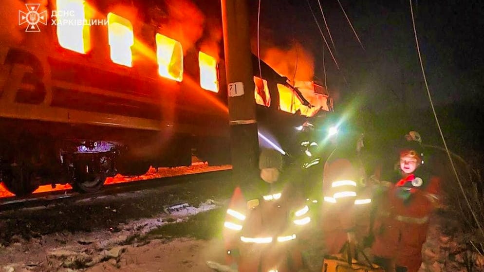HANDOUT - In this photo provided by the Ukrainian Emergency Service, firefighters fight the fire after Russian drones hit a passenger train in the Kharkiv region of Ukraine and set it on fire. Photo: -/Ukrainian Emergency Service/dpa - ATTENTION: For editorial use only and only with full attribution of the above credit