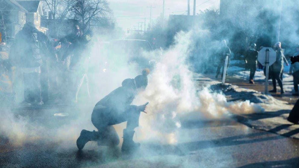 A person attempts to neutralize tear gas used by federal ICE immigration agents in Minneapolis. (January 13, 2026)