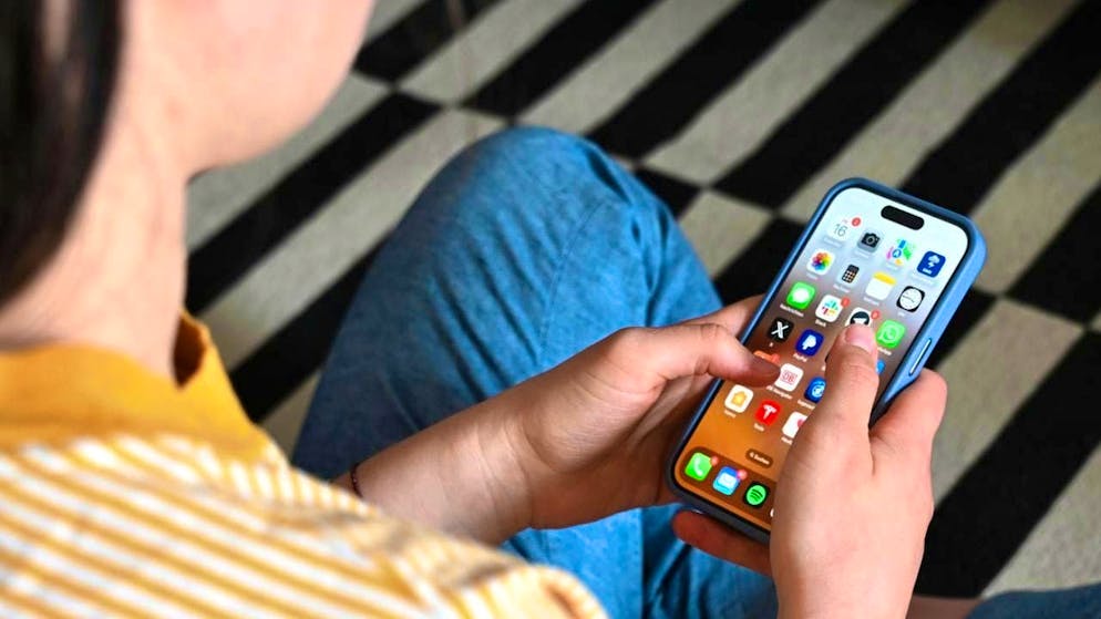 SYMBOL IMAGE - A teenager sits on the floor and uses a smartphone - various apps can be seen on the display. Photo: Elisa Schu/dpa