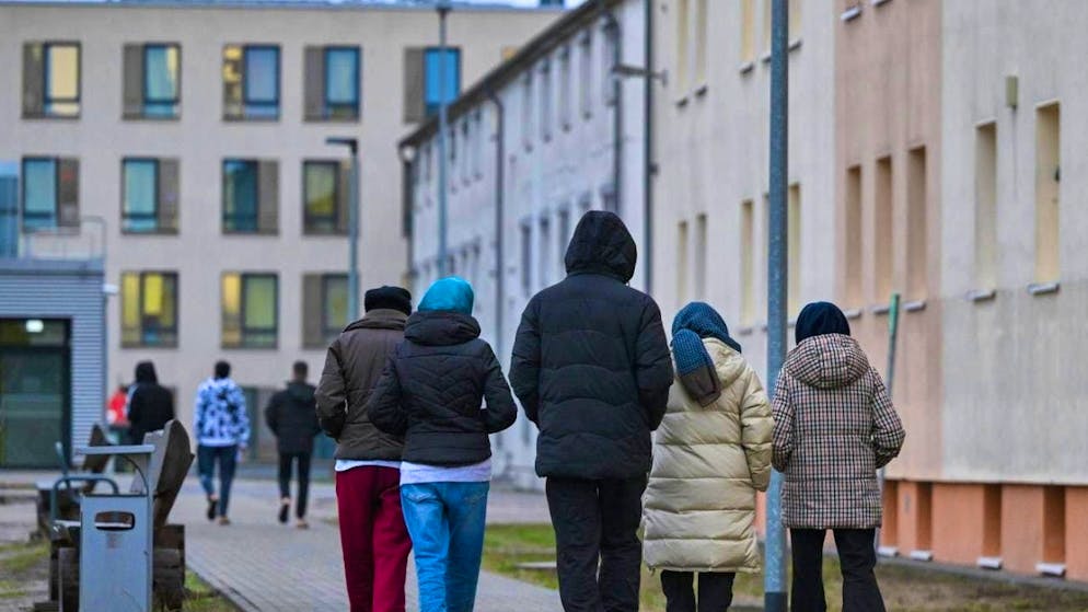 ARCHIVE - Migrants walk across the grounds of a first reception center. The European Commission wants to pursue a strict migration policy over the next five years and at the same time attract skilled workers to the EU. Photo: Patrick Pleul/dpa