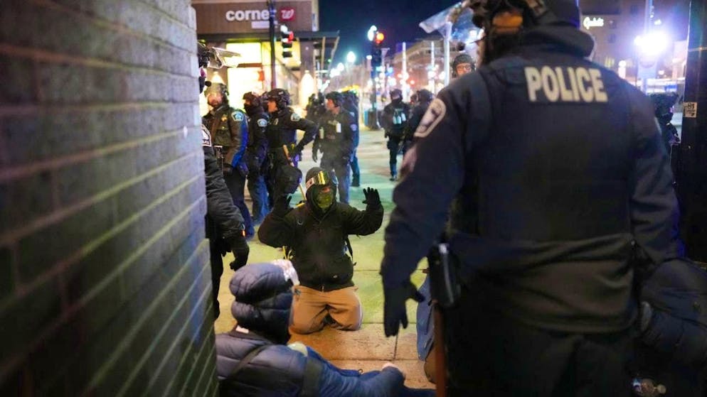 dpatopbilder - A protester raises his arms on the ground as emergency personnel make arrests after declaring an unlawful assembly during a noise demonstration outside the Graduate by Hilton Minneapolis hotel. Photo: Adam Gray/FR172090 AP/AP/dpa