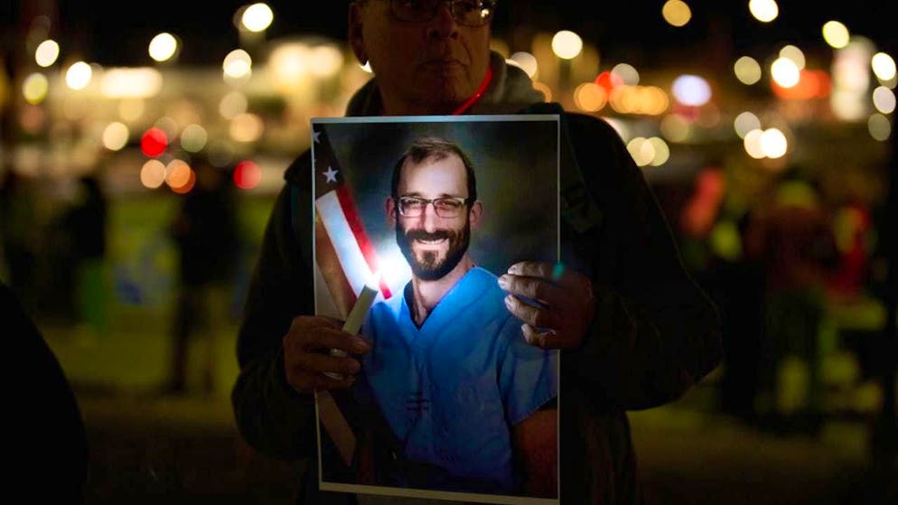 People hold up photos during a vigil for Alex Pretti, who was shot and killed by federal agents in Minneapolis. Photo: John Locher/AP/dpa